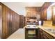 Efficient kitchen featuring essential appliances, lots of cabinets, and wood-paneled walls at 2645 Davenport Rd, Duluth, GA 30096
