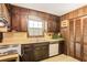 Well-organized kitchen with wood cabinets and appliances, complemented by the wood-paneled walls at 2645 Davenport Rd, Duluth, GA 30096