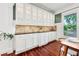 Dining room featuring white cabinetry, granite countertop, and hardwood floors at 2580 Defoors Ferry Nw Rd, Atlanta, GA 30318