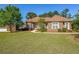Beautifully landscaped front yard with mature trees and a charming brick home at 3230 Letha Woods Dr, Conyers, GA 30094