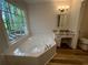 Bright bathroom features a garden tub by a large window with a marble countertop vanity at 3861 Spring Meadow Dr, Acworth, GA 30101