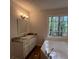 Bathroom with a garden tub, vanity with granite countertops and wood look flooring at 3861 Spring Meadow Dr, Acworth, GA 30101