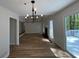 Bright living room featuring new flooring, a modern light fixture, and a sliding glass door to a deck at 3861 Spring Meadow Dr, Acworth, GA 30101