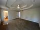 Spacious main bedroom with a tray ceiling, fan, carpet, and doors leading to other rooms at 3861 Spring Meadow Dr, Acworth, GA 30101