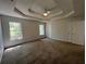Spacious main bedroom with a tray ceiling, fan, carpet, and doors leading to other rooms at 3861 Spring Meadow Dr, Acworth, GA 30101