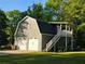Two story garage with gray siding, a two-car garage, an upstairs deck, and stairway access at 4715 Howard Dr, Powder Springs, GA 30127