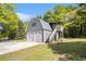 Detached two-car garage with gray siding, stairs, and a deck, situated on a grassy lot at 4715 Howard Dr, Powder Springs, GA 30127