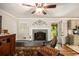Comfortable living room showcasing a fireplace, hardwood floors, ceiling fan, and access to the kitchen at 4715 Howard Dr, Powder Springs, GA 30127