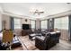 Comfortable living room with plush leather seating, a ceiling fan, and large windows providing ample natural light at 4715 Howard Dr, Powder Springs, GA 30127