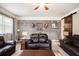 Cozy living room featuring a brick accent wall, comfortable leather seating, and stylish decor, perfect for relaxation at 4715 Howard Dr, Powder Springs, GA 30127