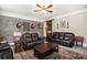 Cozy living room featuring leather seating, brick accent wall, ceiling fan, and stylish decor, perfect for relaxing and entertaining at 4715 Howard Dr, Powder Springs, GA 30127
