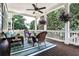 Relaxing back porch features comfortable wicker seating, a ceiling fan, and a view of the trees at 144 Park Dr, Decatur, GA 30030