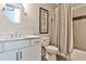 Bathroom with white cabinets, marble countertops, a round mirror and shower-tub creating a tranquil and spa-like experience at 144 Park Dr, Decatur, GA 30030