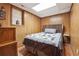 Cozy bedroom featuring a full bed, wood-paneled walls, and laminate flooring at 2816 Pine Meadow Dr, Marietta, GA 30066