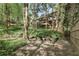 Landscaped backyard featuring a patio, fire pit, and lush greenery with home in the background at 305 Spindle Ct, Sandy Springs, GA 30350