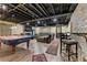 Finished basement with exposed ceiling, brick wall, and recreational area at 305 Spindle Ct, Sandy Springs, GA 30350