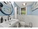 Updated bathroom with a decorative mirror, sink and toilet, and stylish flooring with blue paint at 305 Spindle Ct, Sandy Springs, GA 30350