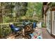 Outdoor patio with seating, a colorful rug, and views of the wooded backyard at 305 Spindle Ct, Sandy Springs, GA 30350