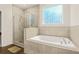 Bright bathroom features a shower, soaking tub, and decorative window for natural light at 790 Riverwood Pass, Dallas, GA 30157