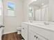 Light-filled bathroom features a double vanity, white cabinets, and wood-look floors at 790 Riverwood Pass, Dallas, GA 30157