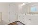 Bathroom boasts double vanity, white cabinets, and neutral tile, providing a clean, modern aesthetic at 790 Riverwood Pass, Dallas, GA 30157