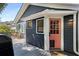 A back porch with gray wood and a cute pink door that gives access to a dining area with outside seating at 1195 Oglethorpe Ne Ave, Atlanta, GA 30319