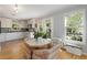 Bright eat-in kitchen features white cabinetry, stainless steel appliances, and wood flooring at 1195 Oglethorpe Ne Ave, Atlanta, GA 30319