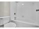 Tiled bathtub and toilet in a bright bathroom at 1410 White Flowers Ln, Lawrenceville, GA 30045