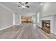 Open-concept living room with hardwood floors, fireplace, and natural light streaming through windows at 1410 White Flowers Ln, Lawrenceville, GA 30045