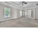 Expansive main bedroom showcasing tray ceilings, plush carpet, and bright windows at 1410 White Flowers Ln, Lawrenceville, GA 30045