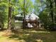 Exterior shot of the home featuring a spacious deck and surrounded by mature trees at 3312 Winter Wood Ct, Marietta, GA 30062