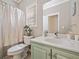 Bathroom features a toilet, shower with curtain, and large sink with green cabinetry at 3338 Hackmatack Nw Dr, Kennesaw, GA 30152