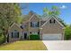 Charming two-story brick home featuring a well-manicured lawn and attached two car garage at 3338 Hackmatack Nw Dr, Kennesaw, GA 30152