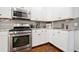 Updated kitchen with white cabinets, stainless steel appliances, and a stylish backsplash at 3338 Hackmatack Nw Dr, Kennesaw, GA 30152