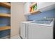 Convenient laundry room with modern washer and dryer, complemented by shelves for storage at 3338 Hackmatack Nw Dr, Kennesaw, GA 30152