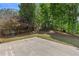 Lush backyard featuring mature trees and a concrete patio perfect for entertaining at 4680 Glen Level Dr, Sugar Hill, GA 30518
