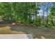 Serene backyard featuring mature trees and lush green grass at 4680 Glen Level Dr, Sugar Hill, GA 30518