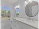 Bright bathroom with dual vanity, stone counters, modern lighting, and a window with natural light at 4680 Glen Level Dr, Sugar Hill, GA 30518