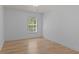 Well-lit bedroom with hardwood floors and natural light from the window at 4680 Glen Level Dr, Sugar Hill, GA 30518