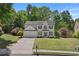 Beautiful two-story home featuring manicured lawn, mature trees, and a classic, inviting facade at 4680 Glen Level Dr, Sugar Hill, GA 30518