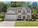 Charming two-story home with a two-car garage, landscaped front yard, and fresh, white exterior at 4680 Glen Level Dr, Sugar Hill, GA 30518