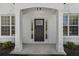 Covered front entryway featuring decorative door, white columns, brick facade, and manicured landscaping at 4680 Glen Level Dr, Sugar Hill, GA 30518