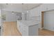 Modern, open-concept kitchen featuring a large island, white cabinets, and stainless steel appliances at 4680 Glen Level Dr, Sugar Hill, GA 30518