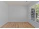 Bright living room featuring hardwood floors, white walls, and a large window with natural light at 4680 Glen Level Dr, Sugar Hill, GA 30518