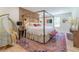 Comfortable bedroom with a canopy bed, accent wall, colorful rug, and unique hanging chair at 5036 Chestnut Forest Ln, Dunwoody, GA 30360