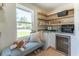 Charming butler's pantry with granite counters, floating shelves, beverage center and view to the outdoors at 5036 Chestnut Forest Ln, Dunwoody, GA 30360