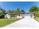 Charming home with a well-manicured lawn, white painted brick, and a spacious concrete driveway at 5036 Chestnut Forest Ln, Dunwoody, GA 30360