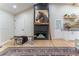 Modern fireplace with stacked stone surround, wooden beam mantle, and birch logs, sitting on light-colored wooden floors at 5036 Chestnut Forest Ln, Dunwoody, GA 30360