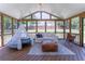 The screened porch features an outdoor living space with comfortable seating, wood floors and wooded backyard views at 5036 Chestnut Forest Ln, Dunwoody, GA 30360