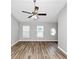 Bright living room featuring wood floors, ceiling fan, and multiple windows allowing for plenty of natural light at 6252 Shenfield Ln, Union City, GA 30291